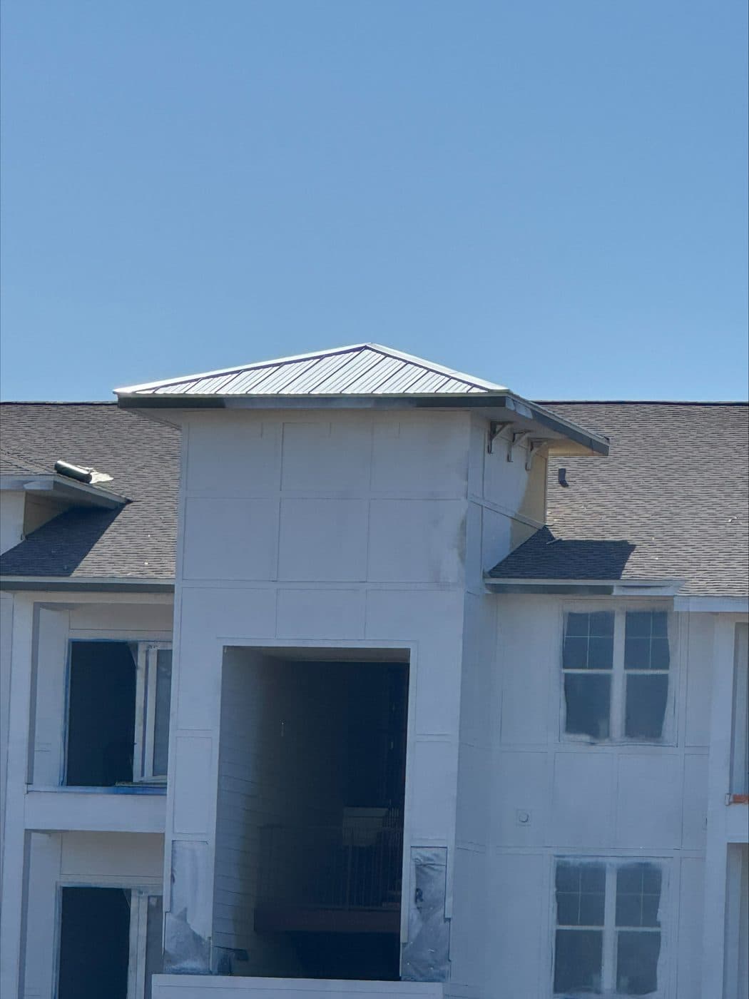 Standing-seam metal roof on the entry tower of a multi-family building under construction