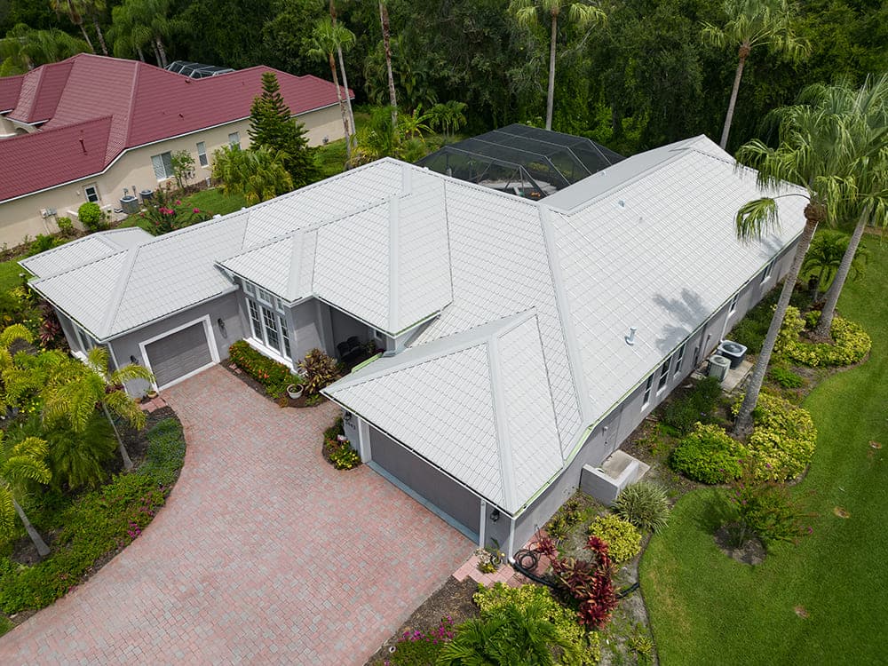 Aerial view of a white standing-seam metal roof with a screened pool enclosure