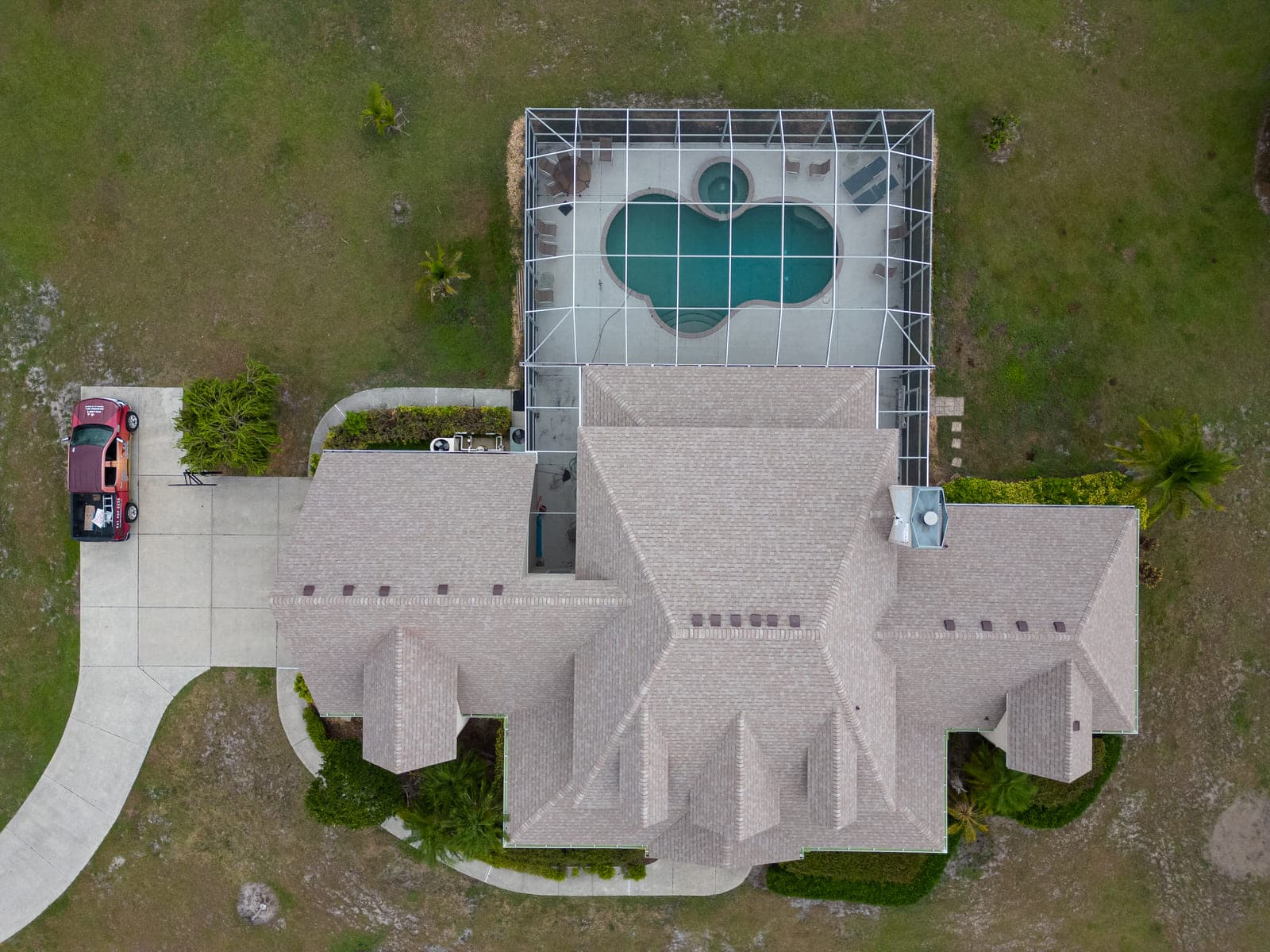 Real Noland's aerial project photo of a tan shingle roof with hips, ridges and a chimney
