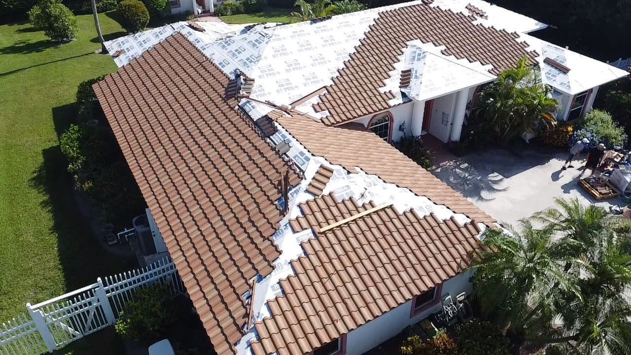 Aerial view of a tile roof installation underway with underlayment still exposed across part of the roof