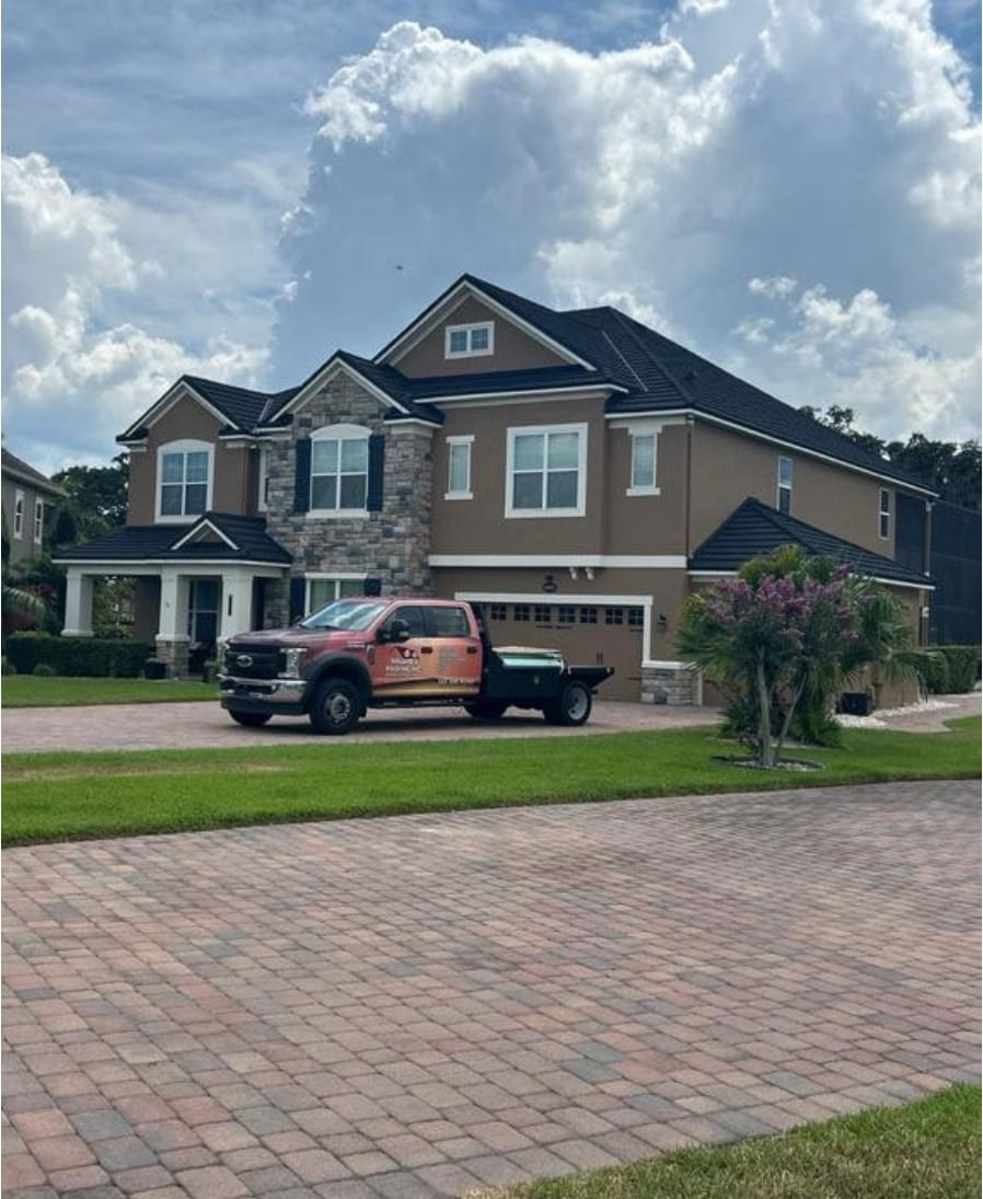 Winter Garden home with a stone-coated metal roof, stone accents and a paver driveway