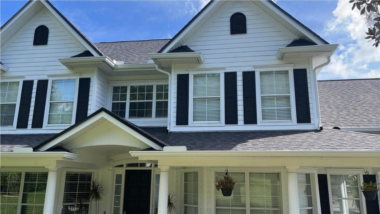 White two-story Clermont home with a CertainTeed Moire Black shingle roof and black shutters
