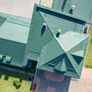 Aerial view of a commercial property with a newly installed green metal roof.