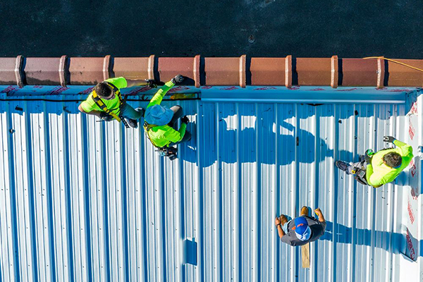 Noland’s Roofing team installing sustainable metal roofing materials, promoting eco-friendly roofing solutions for Florida homes and businesses.