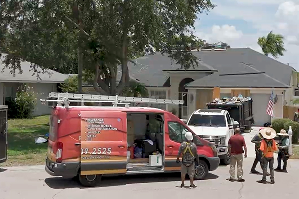 Noland's Roofing crew prepares for a residential roof replacement in Bradenton, Florida. Branded service van and roofing truck parked outside a home while roofers organize equipment. Trusted Bradenton roofers proudly serving surrounding Central Florida cities.