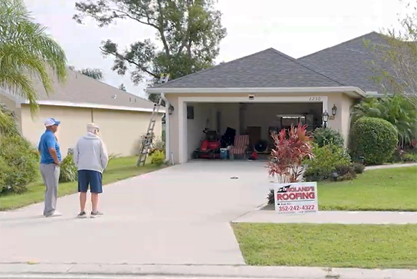 Homeowners speaking with a Noland’s Roofing representative outside a Clermont home, highlighting one of the trusted roofing companies in Clermont for inspections and roof replacements.