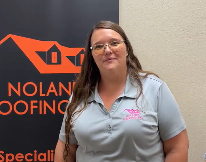 Headshot of Rene Burton who is the contract compliance manager at the clermont Noland's roofing branch. She is wearing a light gray Noland's Roofing branded polo. Standing in front of an orange and black noland's roofing sign.