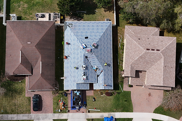 Aerial view of Noland’s Roofing team installing a new roof in Orange City, FL. Roofing crew applying underlayment during a full residential roof replacement.