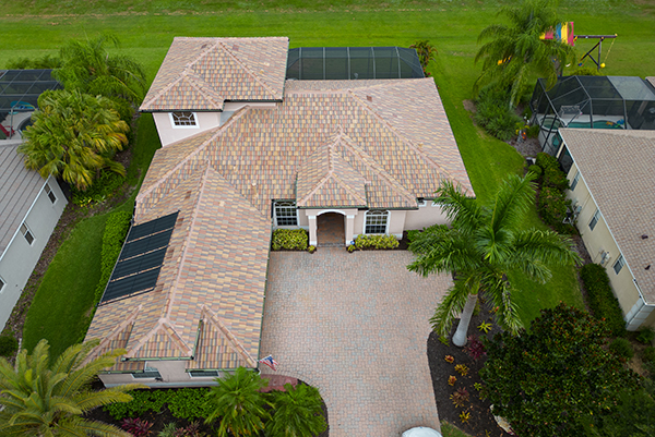 Terracotta tile roof installed by Noland's Roofing on a Florida home, showcasing expert craftsmanship, solar panel integration, and a vibrant tile finish.