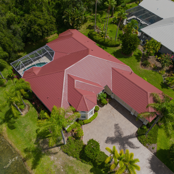Sky view of a house with a red title roof.
