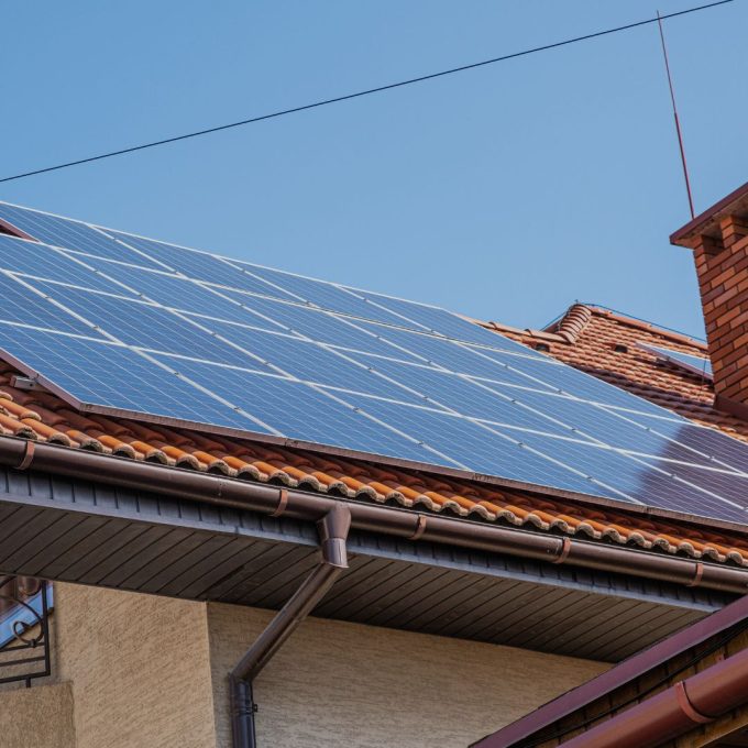 Picture looking up on the tile roof of a residential home with solar panels on the roof